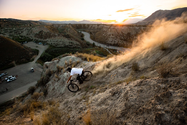 Mountain biker silhouetted against a fiery sunset at Red Bull event