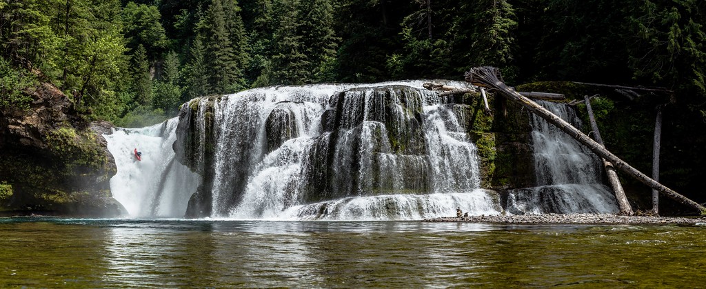 Panoramic view of a cascading waterfall in a lush British Columbia forest
